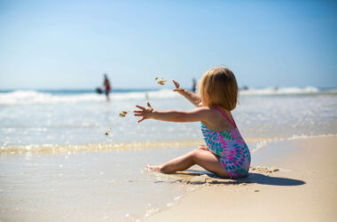 Zon, zee, strand met baby of peuter
